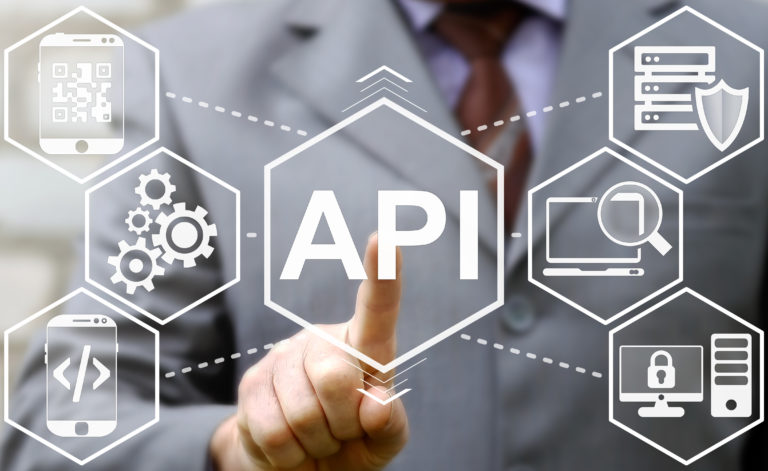 businessman touched API acronym word icon on virtual screen on background of tech devices. Man presses button on touch screen interface and select "API". Business, Internet and technology concept.